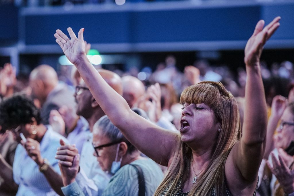 Home A passionate gathering of people in a church worship service, expressing their faith.